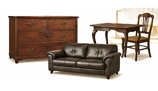 Living room furniture set: a wooden dresser, a small table with two chairs, and a brown leather sofa against a light background.