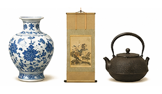 Still life with a blue-and-white porcelain vase, a hanging scroll, and a dark cast-iron teapot on a pale surface.